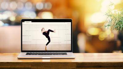 Laptop on a table, with the image of a dancer on screen.