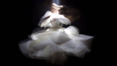 blurry image of a young woman spinning in a puffy white dress