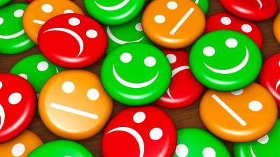 A pile of small colorful disks with expressions: green ones smiling, orange ones neutral, and red ones unhappy.