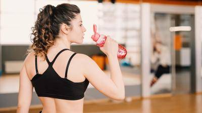 Young woman drinking water after a workout or dance rehearsal