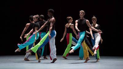 Group of dancers with colorful pants performing on stage the piece "5 Live Calibrations"