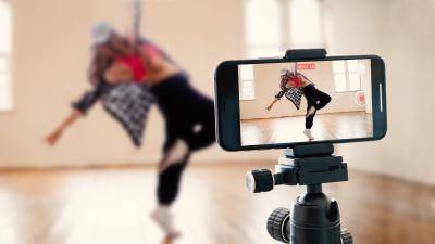 young female dancer videotaping herself dancing