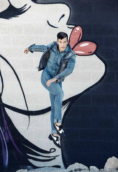 dancer Sean Viator jumping against a painted mural