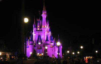 Sleeping Beauty castle lit in pink at night at Walt Disney World Orlando park