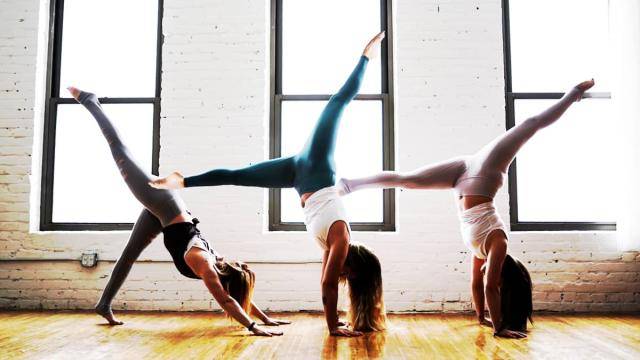 3 dancers doing a hand stand split.