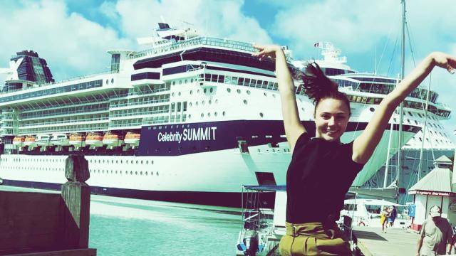 Dancer Kristen Moranetz posing in front of a Celebrity Cruise Ship boat.
