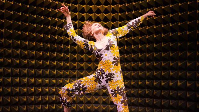 Megan Williams dancing in a white black and yellow flower jumpsuit