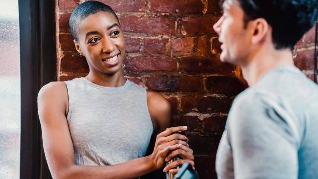 Black woman talking to a caucasian male on a dance class break